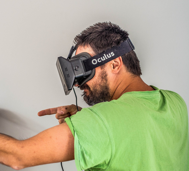 Man experiencing immersive VR in an Oculus Rift headset. Photo credit: Sergey Galyonkin.