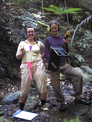 Betsy Roznik (right), armed with a RECCO tracking device to locate tagged frogs, pauses in the forest with a colleague. Photo by Betsy Roznik. 